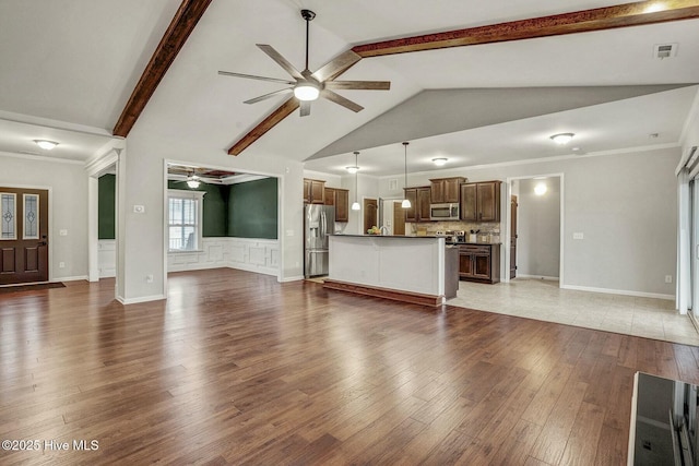 unfurnished living room featuring crown molding, ceiling fan, dark hardwood / wood-style flooring, and beam ceiling