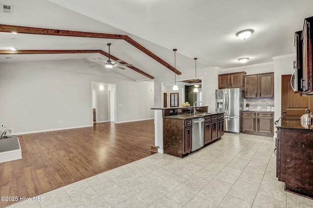 kitchen featuring pendant lighting, sink, ceiling fan, vaulted ceiling with beams, and stainless steel appliances