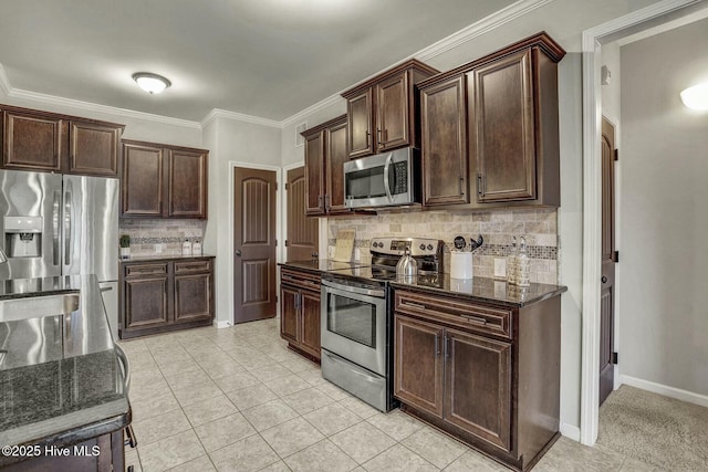 kitchen with backsplash, stainless steel appliances, dark brown cabinets, and dark stone counters