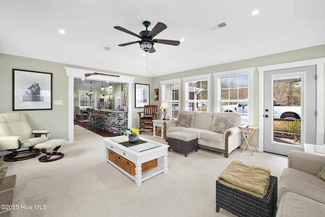 carpeted living room featuring ceiling fan