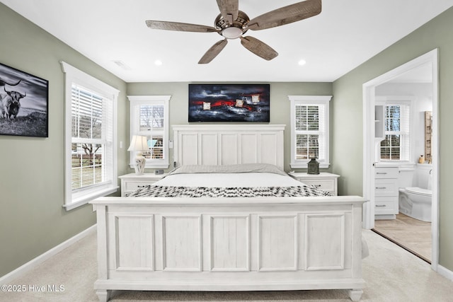 carpeted bedroom with ceiling fan and ensuite bath