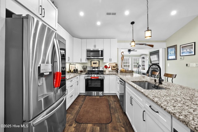 kitchen with appliances with stainless steel finishes, sink, and white cabinets