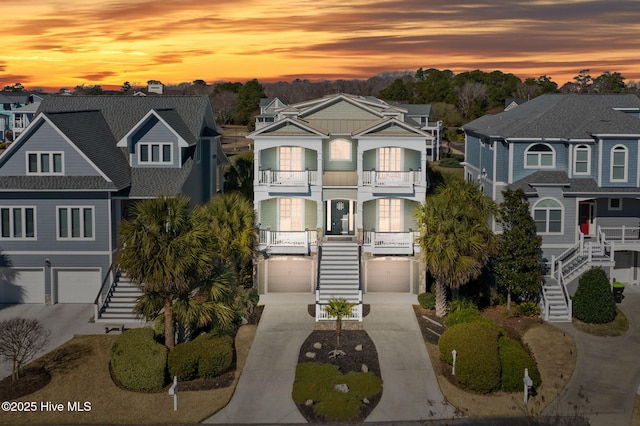 view of front of home with stairway, concrete driveway, and a residential view