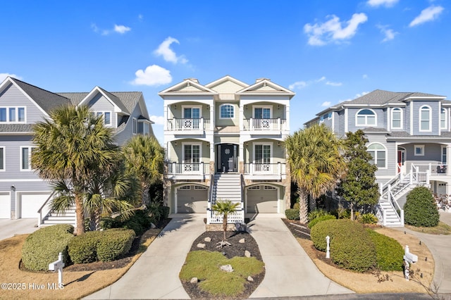 view of front of home with stairway, an attached garage, a residential view, and driveway