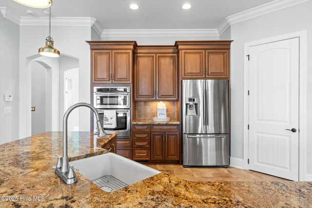 kitchen with premium range hood, black gas stovetop, light stone counters, tasteful backsplash, and brown cabinetry