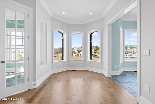 empty room featuring recessed lighting, baseboards, wood finished floors, and crown molding