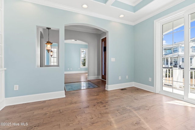 spare room with recessed lighting, wood-type flooring, arched walkways, crown molding, and baseboards