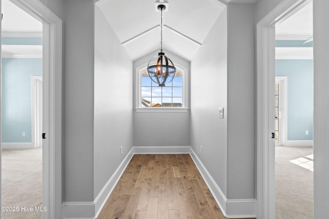 corridor with a notable chandelier, carpet, and ornamental molding