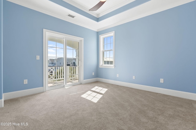 spare room with visible vents, ceiling fan, ornamental molding, light carpet, and a raised ceiling