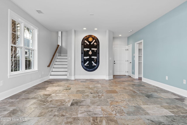 foyer entrance with recessed lighting, stone finish flooring, baseboards, and stairs