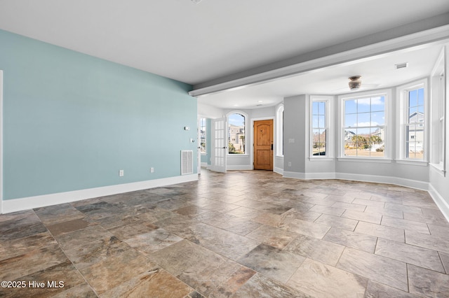 unfurnished living room featuring stone finish floor, baseboards, and visible vents