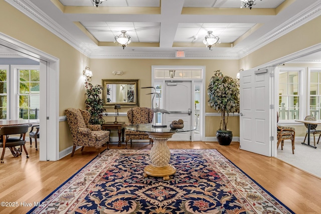 interior space with beamed ceiling, ornamental molding, coffered ceiling, and light hardwood / wood-style floors