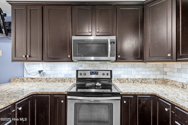 kitchen featuring light stone counters, backsplash, dark brown cabinets, and appliances with stainless steel finishes