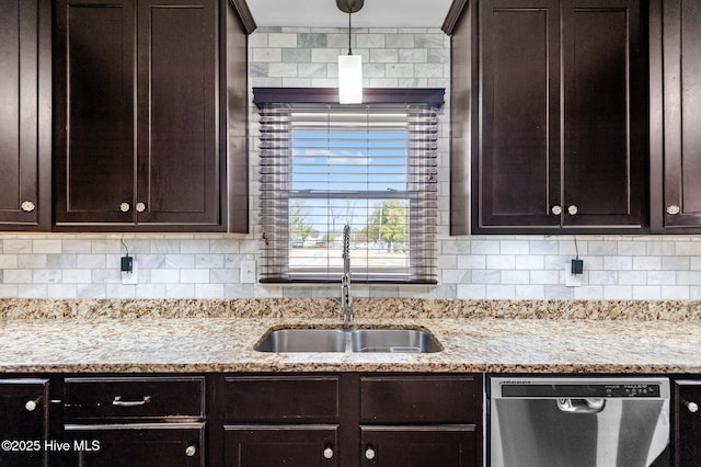 kitchen with pendant lighting, sink, dishwasher, light stone counters, and decorative backsplash