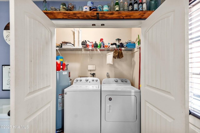 washroom with water heater and washing machine and dryer