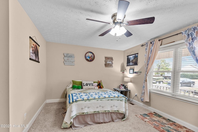 bedroom with ceiling fan, light carpet, and a textured ceiling