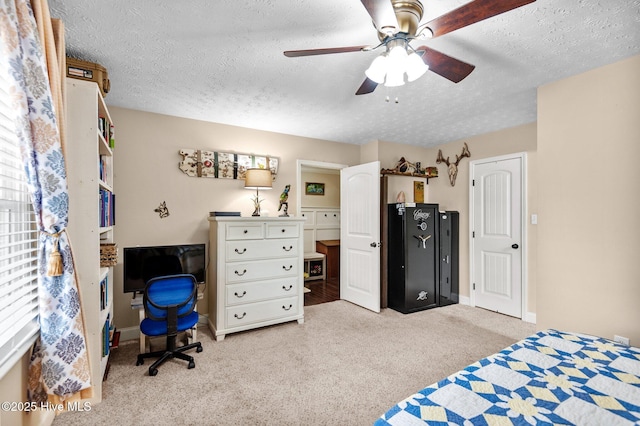 carpeted bedroom featuring ceiling fan and a textured ceiling