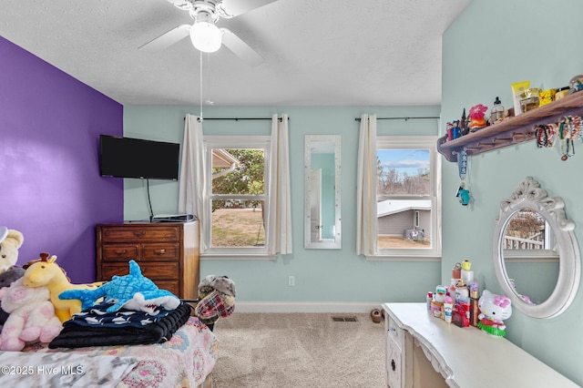 carpeted bedroom featuring ceiling fan and a textured ceiling