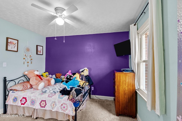 bedroom with ceiling fan, carpet flooring, and a textured ceiling