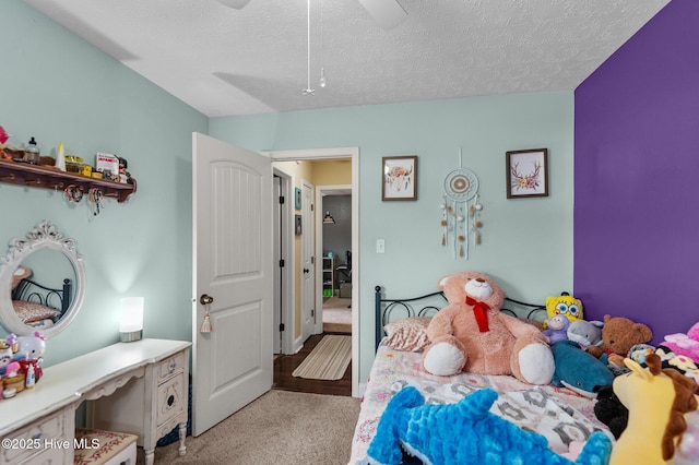 carpeted bedroom with ceiling fan and a textured ceiling