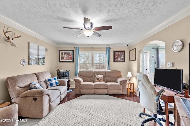 living room featuring ceiling fan, ornamental molding, dark hardwood / wood-style flooring, and a textured ceiling