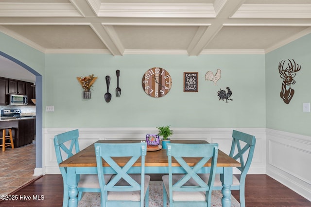 dining space with coffered ceiling, dark wood-type flooring, ornamental molding, and beamed ceiling