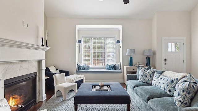 living room with hardwood / wood-style flooring, a tile fireplace, and ceiling fan