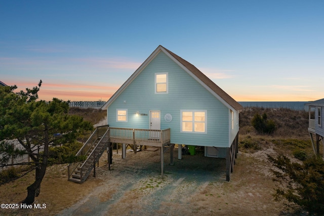 back of house featuring stairs, a carport, and driveway