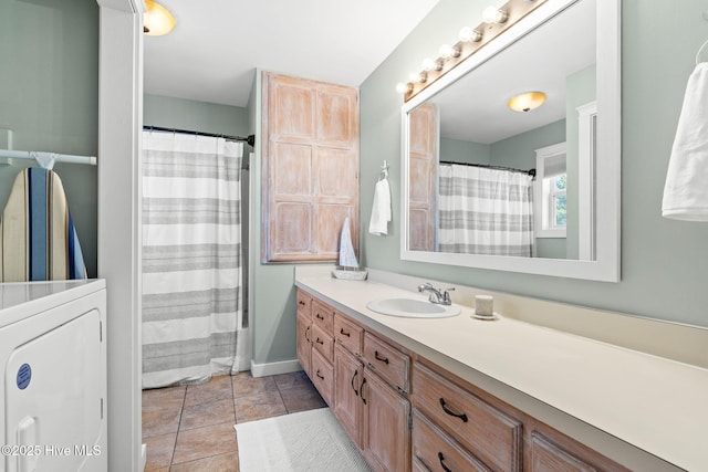 full bathroom with washer / dryer, vanity, and tile patterned floors