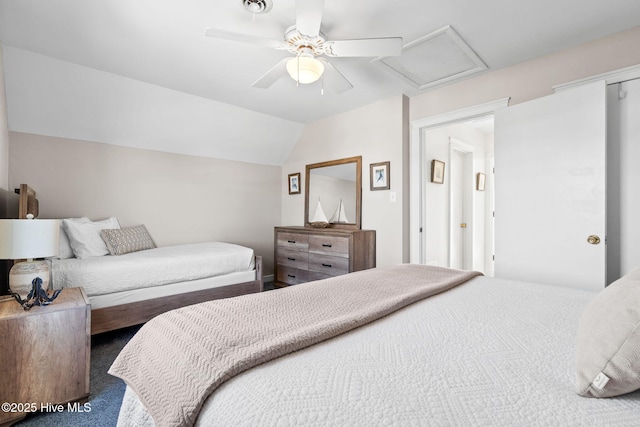 bedroom with carpet, visible vents, attic access, vaulted ceiling, and ceiling fan