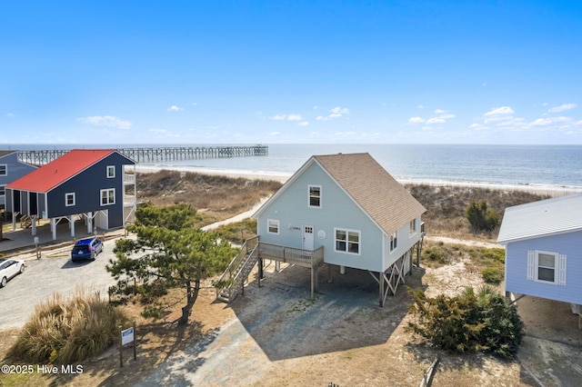 drone / aerial view featuring a water view and a view of the beach