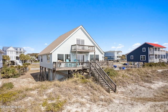 back of property featuring a deck, a balcony, and stairs