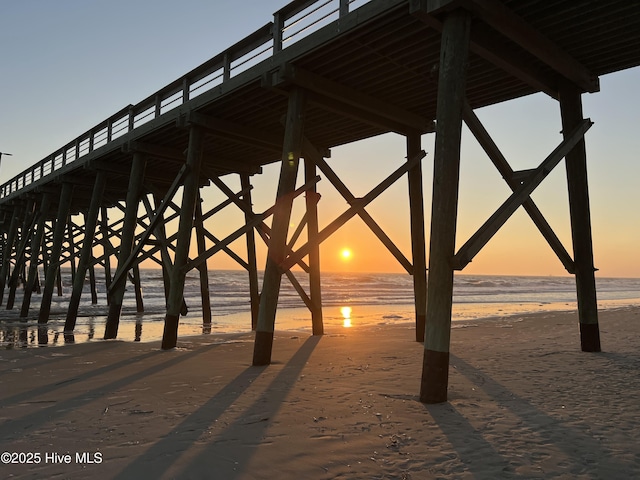 surrounding community featuring a water view, a view of the beach, and a pier