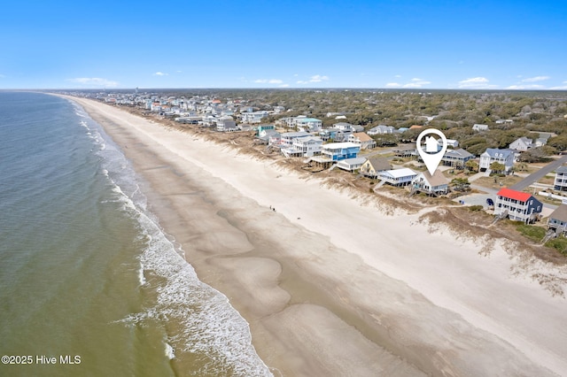 birds eye view of property with a water view and a beach view