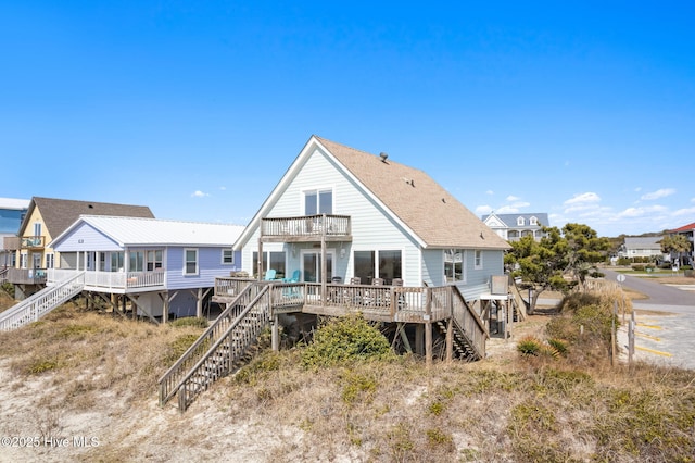 rear view of property with a deck, a residential view, a balcony, and stairs