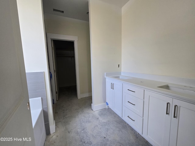 bathroom with vanity, concrete flooring, and a tub