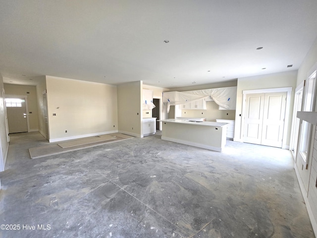 unfurnished living room with concrete flooring