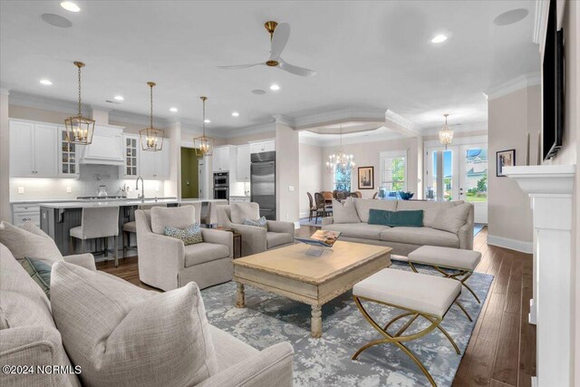 dining area with a notable chandelier, a raised ceiling, visible vents, wood finished floors, and baseboards