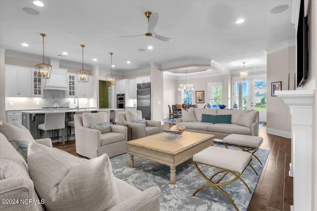 living area with recessed lighting, ceiling fan with notable chandelier, dark wood-style flooring, baseboards, and ornamental molding