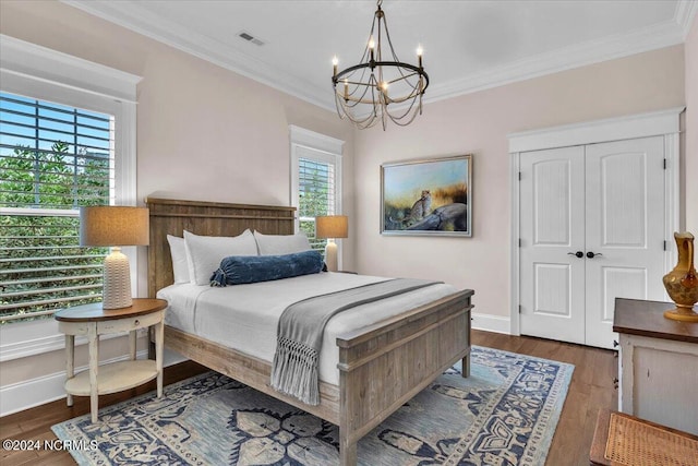 bedroom featuring a chandelier, visible vents, baseboards, dark wood finished floors, and crown molding