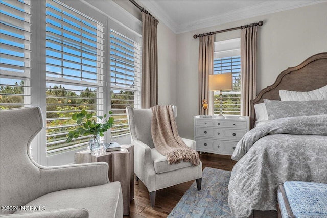 bedroom with ornamental molding and wood finished floors