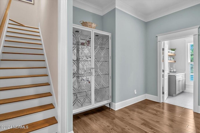 interior space with crown molding, stairs, baseboards, and wood finished floors