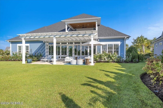 rear view of property featuring a patio area, a shingled roof, a lawn, and a pergola