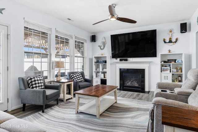 living room featuring wood-type flooring and ceiling fan