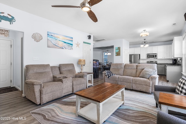 living room with sink, ceiling fan, and light hardwood / wood-style flooring