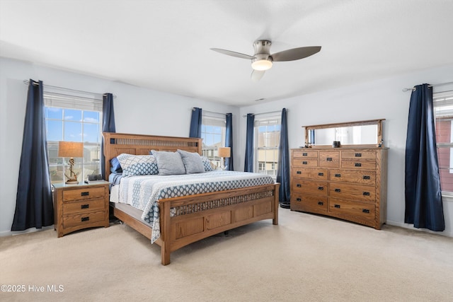 bedroom with multiple windows, light carpet, and ceiling fan