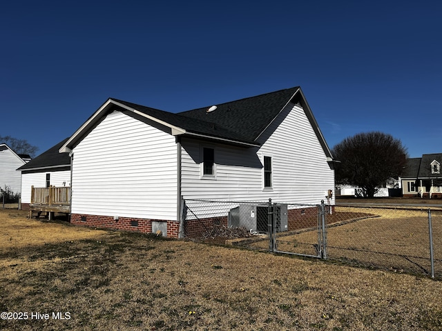 view of side of home with a yard and central AC