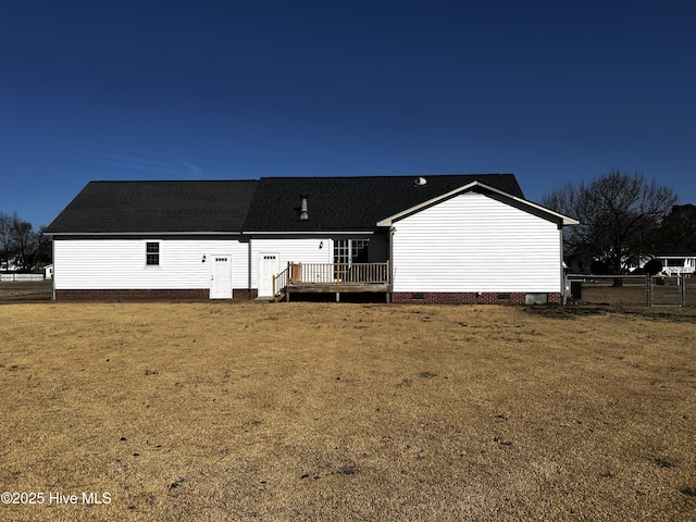 back of property with a yard and a deck