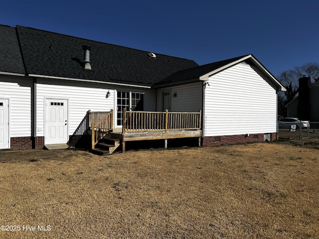 back of house featuring a deck and a lawn