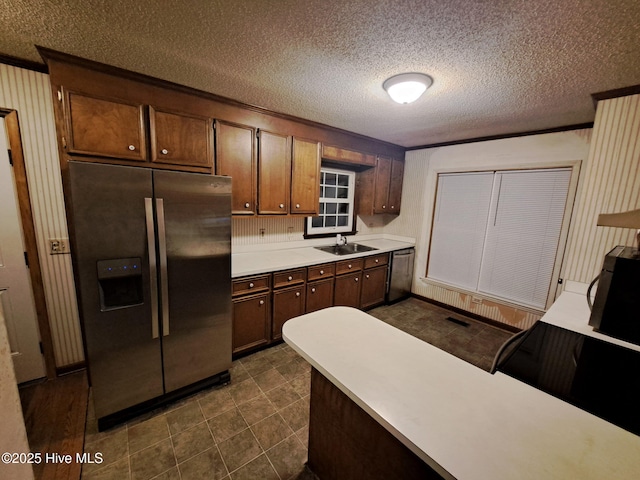 kitchen featuring stainless steel appliances, sink, and a textured ceiling